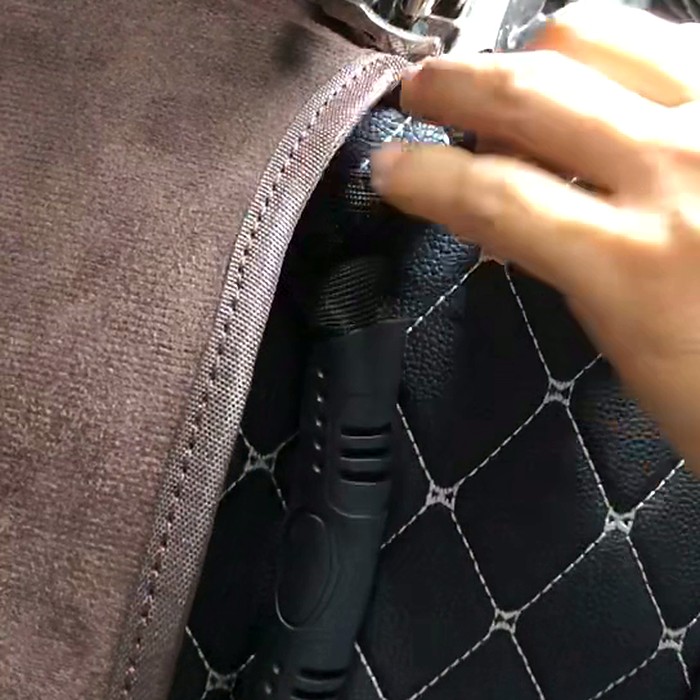 DINLEEYの自社生産ラインで、キルティングのシートバックオーガナイザーの縁にバインディングテープを縫い付けている様子。