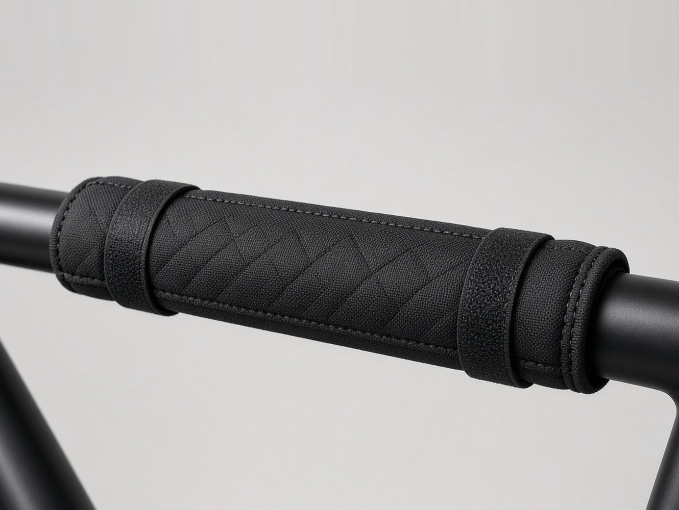 Padded, stitched top-tube protector wrapped on a bicycle frame with hook-and-loop straps