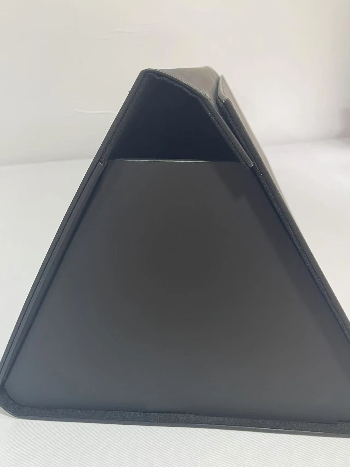 End view of a board-reinforced folding storage box sample showing panel angles and edge binding.